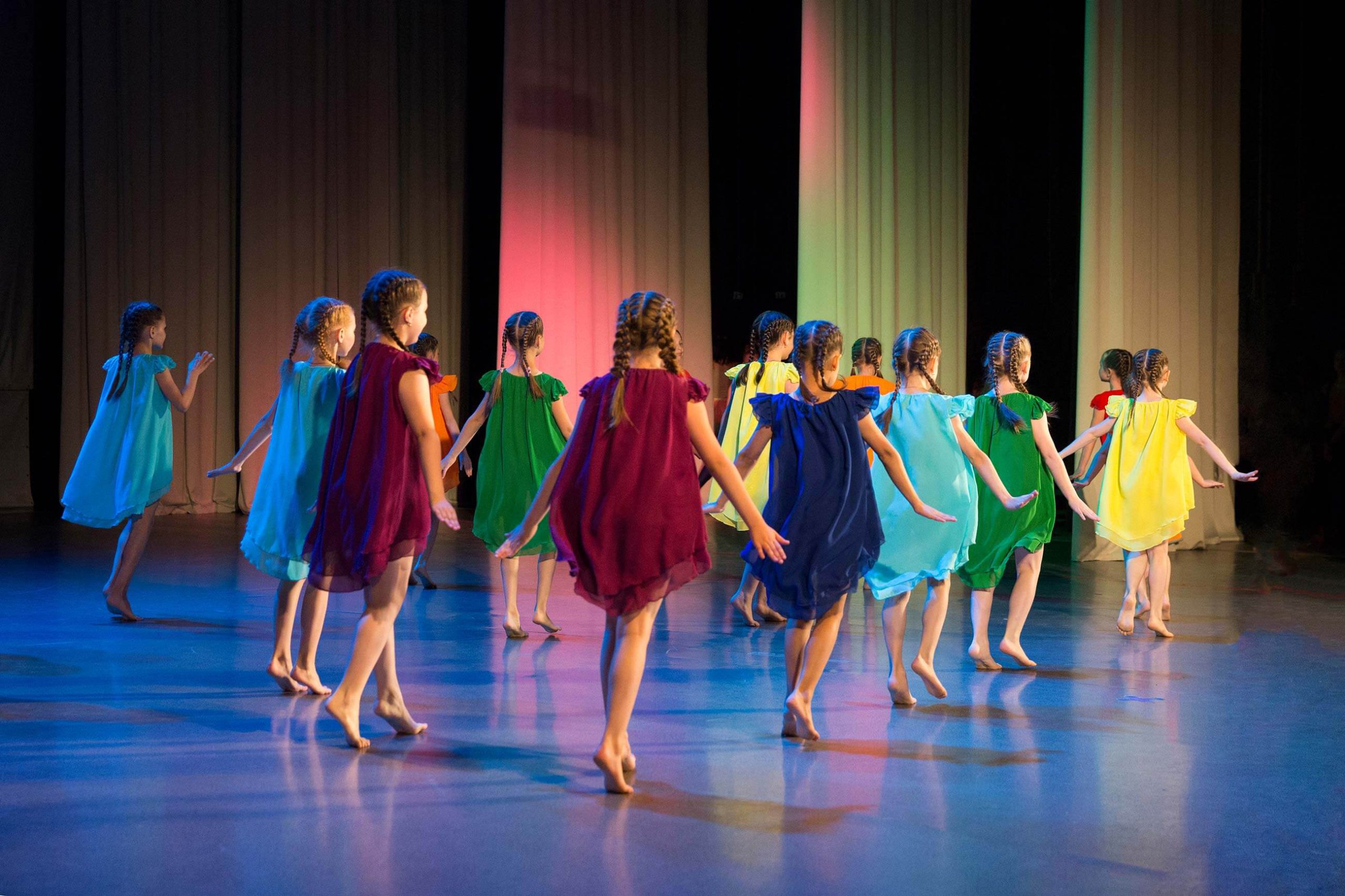 Dancing Girls running off stage in colourful dresses